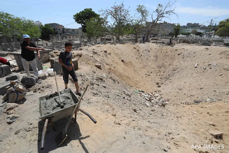 Palestinians inspect the damage around tombs in the old Shujaiya cemetery in Gaza City on May 30, 2021, after recent Israeli bombings. A ceasefire was reached late last week after 11 days of deadly violence between Israe...