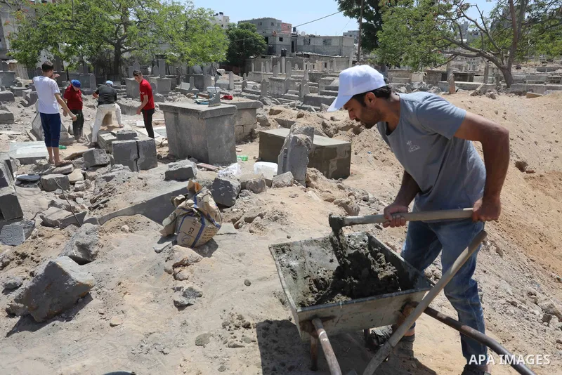 Palestinians inspect the damage around tombs in the old Shujaiya cemetery in Gaza City on May 30, 2021, after recent Israeli bombings. A ceasefire was reached late last week after 11 days of deadly violence between Israe...