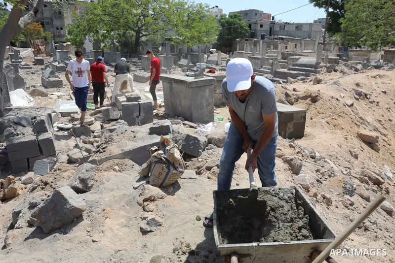 Palestinians inspect the damage around tombs in the old Shujaiya cemetery in Gaza City on May 30, 2021, after recent Israeli bombings. A ceasefire was reached late last week after 11 days of deadly violence between Israe...