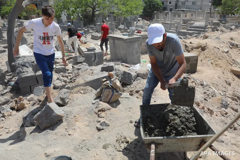 Palestinians inspect the damage around tombs in the old Shujaiya cemetery in Gaza City on May 30, 2021, after recent Israeli bombings. A ceasefire was reached late last week after 11 days of deadly violence between Israe...