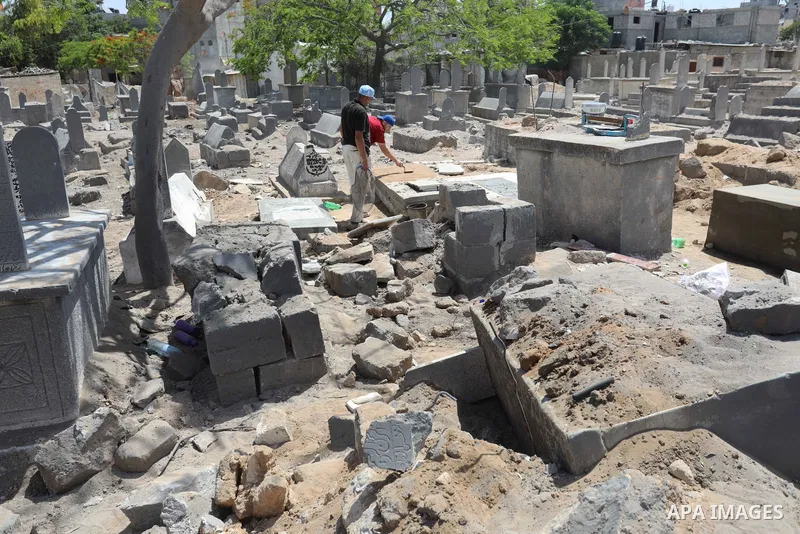 Palestinians inspect the damage around tombs in the old Shujaiya cemetery in Gaza City on May 30, 2021, after recent Israeli bombings. A ceasefire was reached late last week after 11 days of deadly violence between Israe...