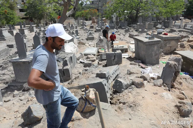 Palestinians inspect the damage around tombs in the old Shujaiya cemetery in Gaza City on May 30, 2021, after recent Israeli bombings. A ceasefire was reached late last week after 11 days of deadly violence between Israe...