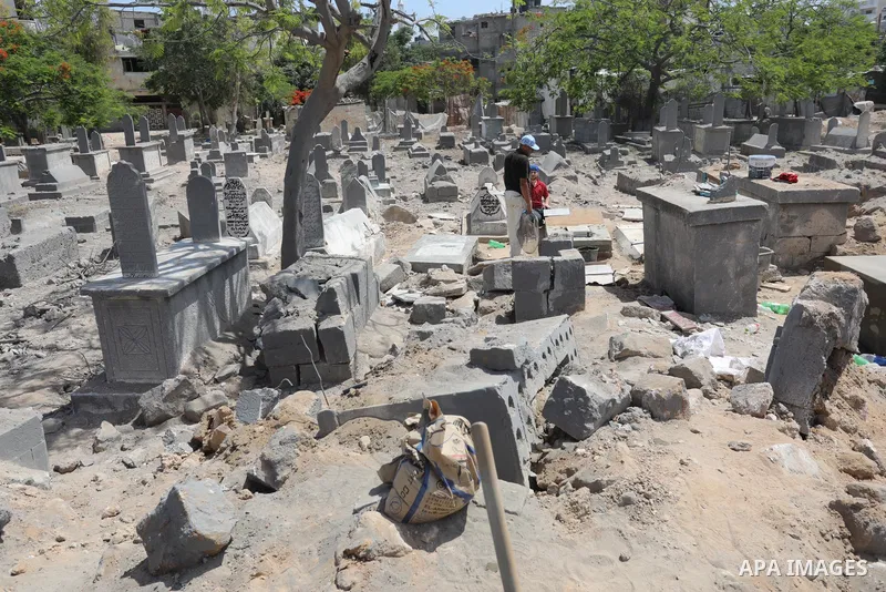 Palestinians inspect the damage around tombs in the old Shujaiya cemetery in Gaza City on May 30, 2021, after recent Israeli bombings. A ceasefire was reached late last week after 11 days of deadly violence between Israe...