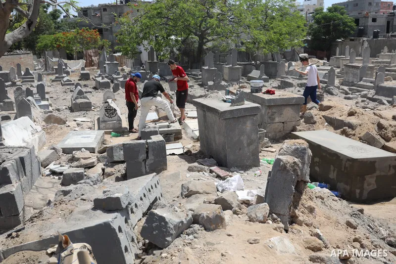 Palestinians inspect the damage around tombs in the old Shujaiya cemetery in Gaza City on May 30, 2021, after recent Israeli bombings. A ceasefire was reached late last week after 11 days of deadly violence between Israe...