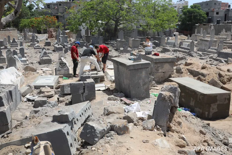 Palestinians inspect the damage around tombs in the old Shujaiya cemetery in Gaza City on May 30, 2021, after recent Israeli bombings. A ceasefire was reached late last week after 11 days of deadly violence between Israe...