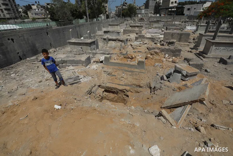 Palestinians inspect the damage around tombs in the old Shujaiya cemetery in Gaza City on May 30, 2021, after recent Israeli bombings. A ceasefire was reached late last week after 11 days of deadly violence between Israe...