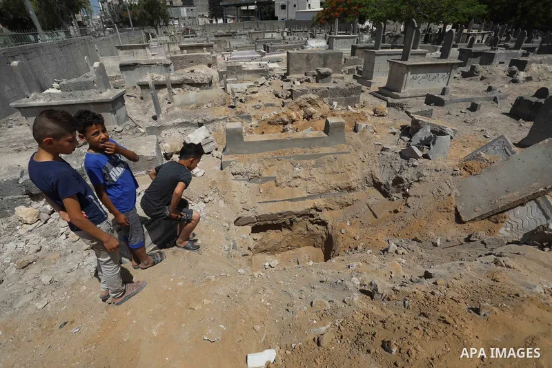 Palestinians inspect the damage around tombs in the old Shujaiya cemetery in Gaza City on May 30, 2021, after recent Israeli bombings. A ceasefire was reached late last week after 11 days of deadly violence between Israe...