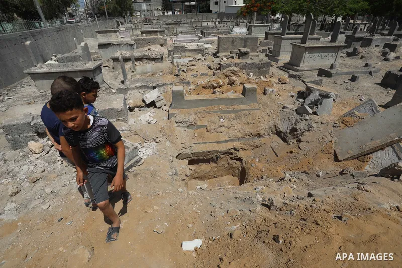Palestinians inspect the damage around tombs in the old Shujaiya cemetery in Gaza City on May 30, 2021, after recent Israeli bombings. A ceasefire was reached late last week after 11 days of deadly violence between Israe...