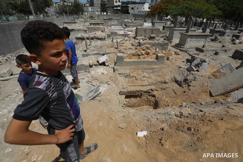Palestinians inspect the damage around tombs in the old Shujaiya cemetery in Gaza City on May 30, 2021, after recent Israeli bombings. A ceasefire was reached late last week after 11 days of deadly violence between Israe...