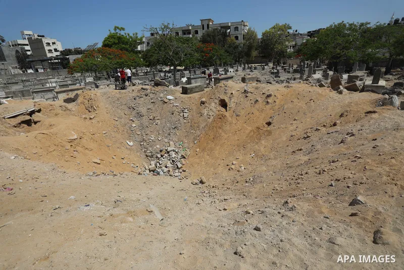 Palestinians inspect the damage around tombs in the old Shujaiya cemetery in Gaza City on May 30, 2021, after recent Israeli bombings. A ceasefire was reached late last week after 11 days of deadly violence between Israe...