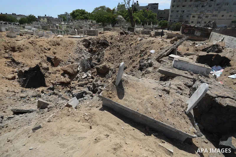 Palestinians inspect the damage around tombs in the old Shujaiya cemetery in Gaza City on May 30, 2021, after recent Israeli bombings. A ceasefire was reached late last week after 11 days of deadly violence between Israe...