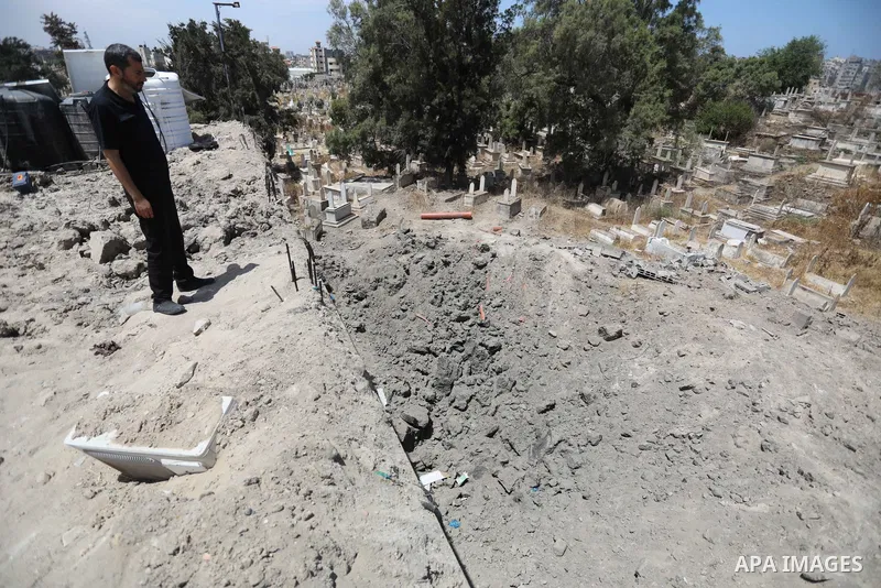 Palestinians inspect the damage around tombs in the old Shujaiya cemetery in Gaza City on May 30, 2021, after recent Israeli bombings. A ceasefire was reached late last week after 11 days of deadly violence between Israe...