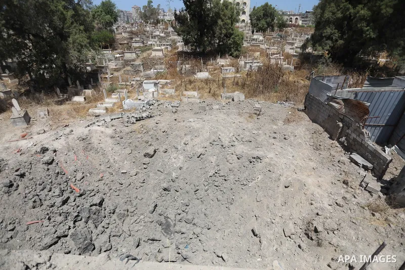 Palestinians inspect the damage around tombs in the old Shujaiya cemetery in Gaza City on May 30, 2021, after recent Israeli bombings. A ceasefire was reached late last week after 11 days of deadly violence between Israe...