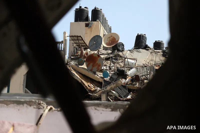 Palestinians inspect the rubbles of a building destroyed by Israeli air strikes at al-Shati refugee camp, in Gaza city on May 11, 2021. woman was killed this morning when Israel warplanes attacked a residential building...