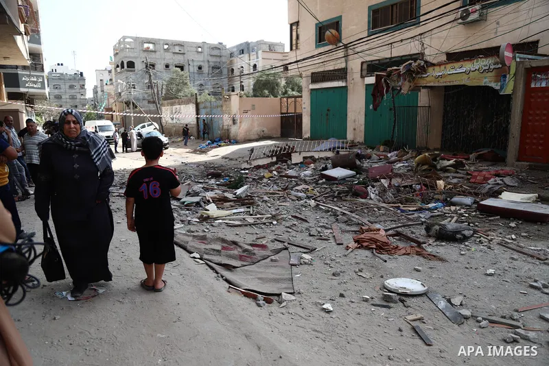Palestinians inspect the rubbles of a building destroyed by Israeli air strikes at al-Shati refugee camp, in Gaza city on May 11, 2021. woman was killed this morning when Israel warplanes attacked a residential building...