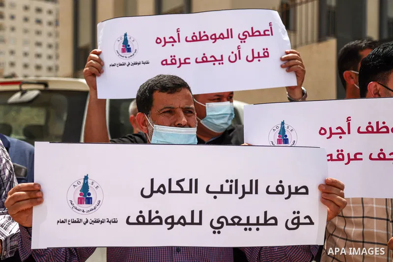 Palestinian employees in the Gaza Strip, take part in a protest demanding a payment before Eid Al-Fitr, in front of the Ministry of Finance headquarters, in Gaza city, on May 9, 2021. The union of public sector employees...