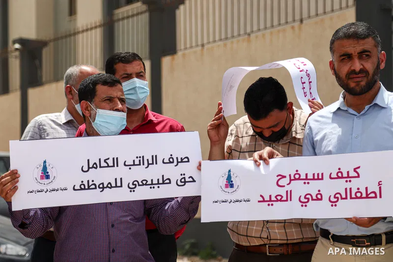 Palestinian employees in the Gaza Strip, take part in a protest demanding a payment before Eid Al-Fitr, in front of the Ministry of Finance headquarters, in Gaza city, on May 9, 2021. The union of public sector employees...
