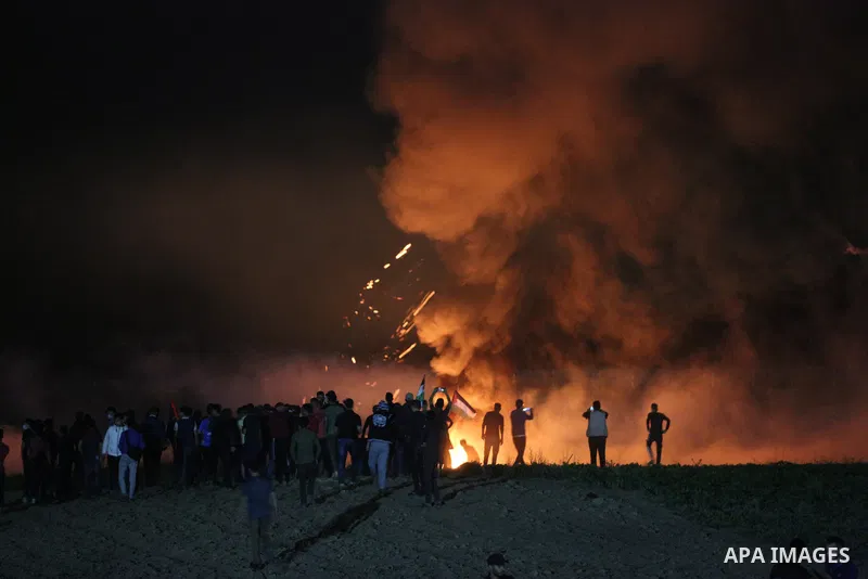 Palestinians gather amid burning tire fumes and tear gas fired by Israeli security forces during a demonstration by the Israel-Gaza border, in al-Bureij in the central Gaza Strip, on May 8, 2021. Earlier last night, thre...