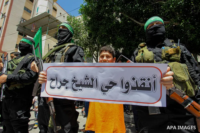 Palestinians and members of Ezz-Al Din Al-Qassam Brigades, the armed wing of the Hamas movemen take part in a prtoest in solidarity with Sheikh Jarrah neighbourhood, in Jabalia in the nothern of Gaza Strip on May 07, 202...