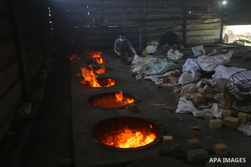 Palestinian chefs cook chickens and rice on firewood by burying them inside a barrel underground, to sell it to customers during the holy month of Ramadan in Deir al-Balah in the center of Gaza Strip, aimd the COVID-19 p...