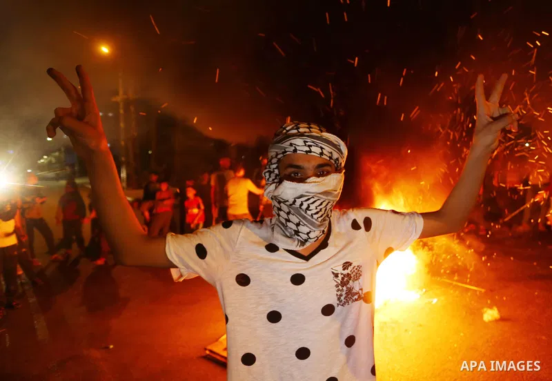 Palestinians chant slogans as they burn tires during a rally in support of the Al-Aqsa Mosque, in Deir al-Balah, in the center of Gaza strip on April 25, 2021. There have been nightly disturbances since the start of the...