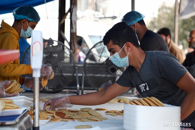 Abu Wisam Saqallah, a Paletsinian man prepares "Qatayef'' traditional pancakes that are popular on Muslim holy month of Ramadan with his family to sell it for customers in Gaza city on April 26, 2021. Celebrations in Gaz...