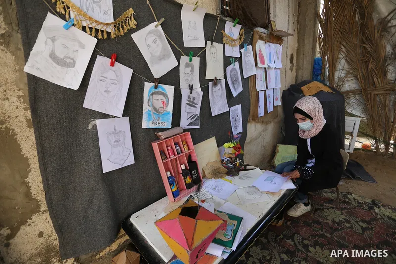 Palestinian artist Asma al-Aqra'a a paints a painting depicting ballot boxes at her home in the Deir al-Balah in the center of Gaza Strip, before Palestinian general election on April 29, 2021. Palestinians are preparing...