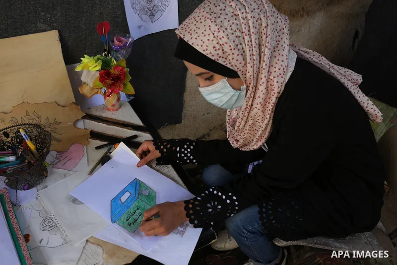 Palestinian artist Asma al-Aqra'a a paints a painting depicting ballot boxes at her home in the Deir al-Balah in the center of Gaza Strip, before Palestinian general election on April 29, 2021. Palestinians are preparing...