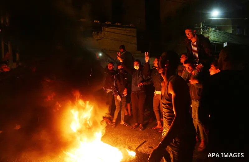 Palestinians burn tyre as they shout slogans during a protest in support of the Al-Aqsa Mosque in Deir Al-Balah in the center of Gaza strip, on April 24, 2021. Israeli police scuffled with Palestinians for a second night...