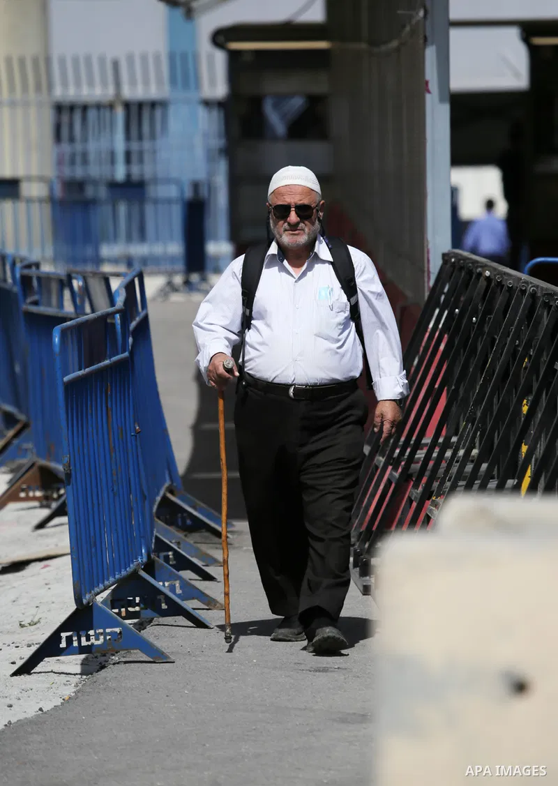 Members of the Israeli security forces stand guard at the Qalandia checkpoint between the West Bank town of Ramallah and Jerusalem, as Palestinians cross to attend the second Friday prayers of the fasting month of Ramada...