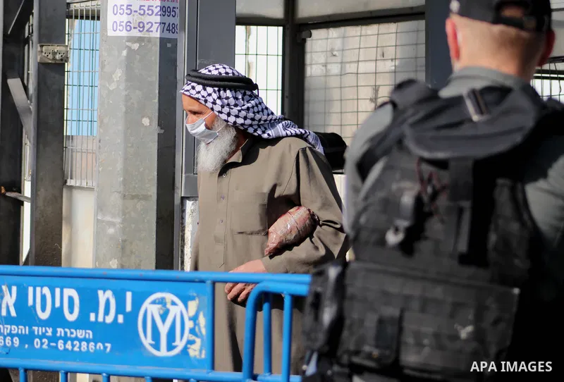 Palestinians entering Jerusalem to attend the first Friday prayers of the Muslim fasting month of Ramadan at the Al-Aqsa Mosque, show their covid-19 vaccination certificates to Israeli security forces at a checkpoint nea...
