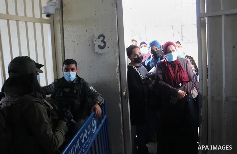 Palestinians entering Jerusalem to attend the first Friday prayers of the Muslim fasting month of Ramadan at the Al-Aqsa Mosque, show their covid-19 vaccination certificates to Israeli security forces at a checkpoint nea...