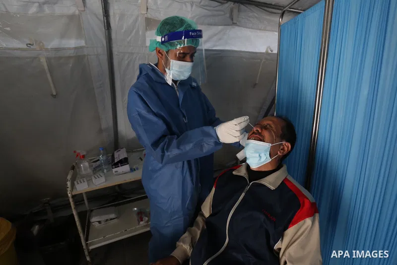 A Palestinian health worker collects a swab sample from a person for Covid-19 test in Deir al-Balah in the central Gaza Strip, on April 8, 2021. Hospitals in the Palestinian Territories of the West Bank and Gaza are bein...
