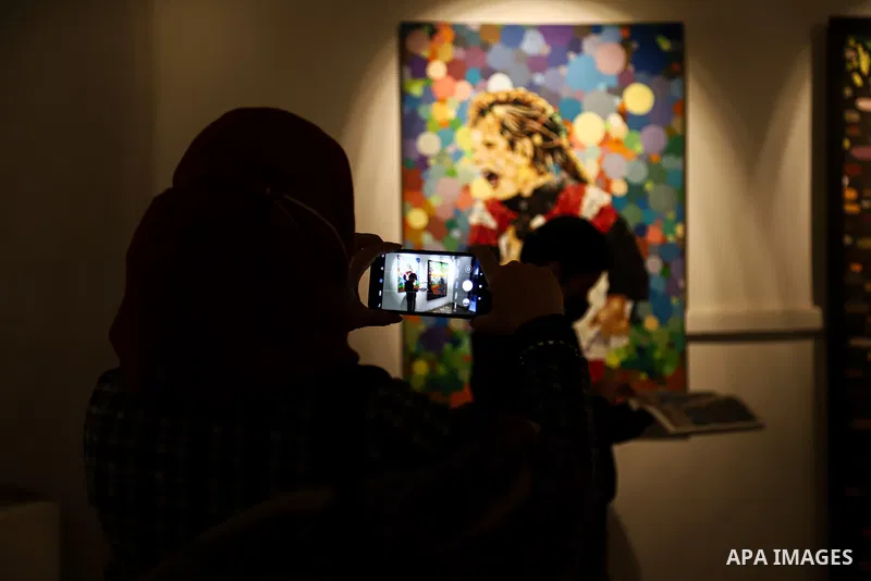 Palestinians attend an exhibition of the artist Mohammad Alkrunz, entitled "camp countryside", in Gaza city, on March 30, 2021. Photo by Mohammed Salem