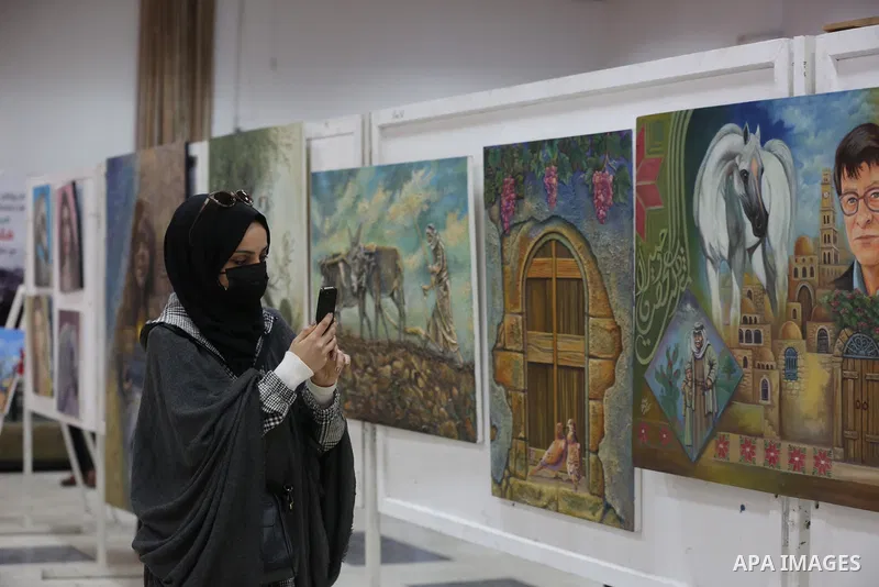 Palestinians attend the first international exhibition in Palestine for plastic art entitled (Palestine is a land and a people), inside the YMCA in Gaza City on March 29, 2021. Contemporary Palestinian art finds its root...