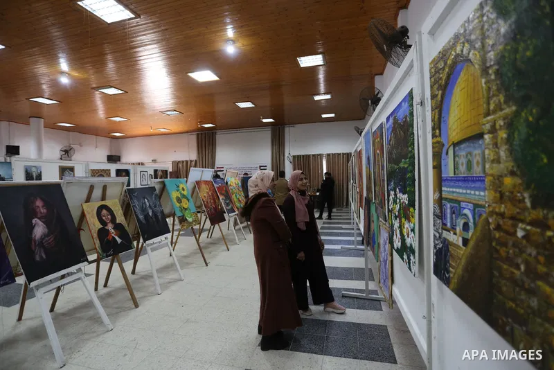 Palestinians attend the first international exhibition in Palestine for plastic art entitled (Palestine is a land and a people), inside the YMCA in Gaza City on March 29, 2021. Contemporary Palestinian art finds its root...