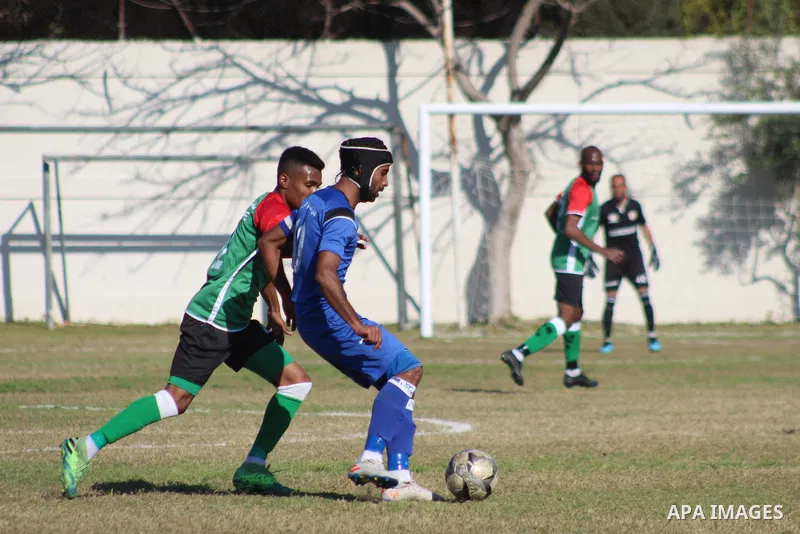 Palestinian football players of Shabab Jabalia (blue) and Khadamat Rafah club (green) compete during match premier League in Beit Lahia Stadium, in Beit Lahia in the northern Gaza Strip on March 28, 2021. Photo by Mariha...