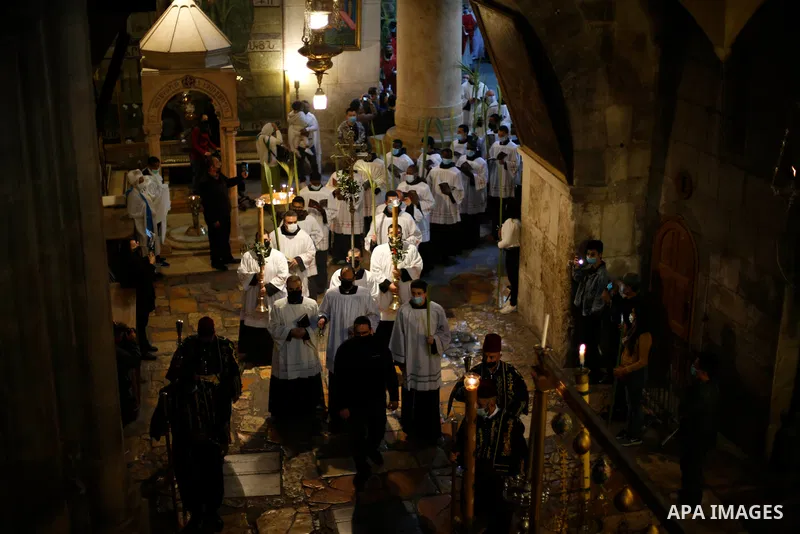Christian worshippers hold palm fronds during a Palm Sunday procession in the Church of the Holy Sepulchre in Jerusalem's Old City March 28, 2021. Palm Sunday, which is the biblical account of Jesus Christ's entry into J...