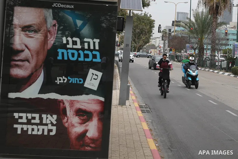 A picture taken on March 21, 2021, shows a campaign billboard for Israel's Blue and White opposition party led by Benny Gantz depicting him and Israeli Prime Minister Benjamin Netanyahu of the Likud party, which reads in...