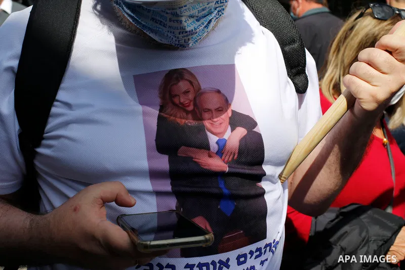 Supporters of Israel's Likud party lift a banner depicting Prime Minister Benjamin Netanyahu during the elections campaign at Mahane Yehuda market in Jerusalem, on March 19, 2021. Candidates hit the streets ahead of Marc...