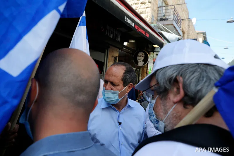 Supporters of Israel's Likud party lift a banner depicting Prime Minister Benjamin Netanyahu during the elections campaign at Mahane Yehuda market in Jerusalem, on March 19, 2021. Candidates hit the streets ahead of Marc...
