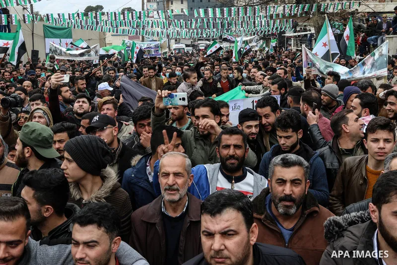 Protesters wave flags of the Syrian opposition during a demonstration in the town of Azaz in the rebel-controlled northern countryside of Syria's Aleppo province, on March 15, 2021, marking ten years since the nationwide...
