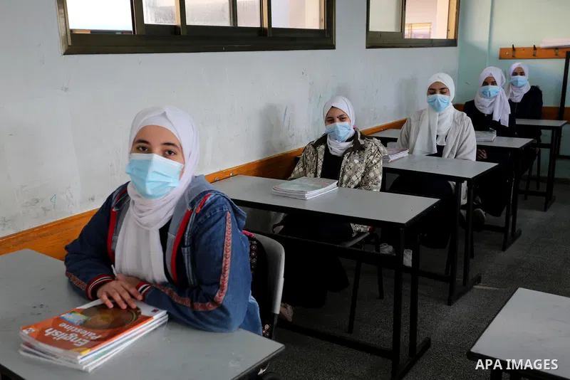 Palestinian students wearing protective face masks, sit in a classroom, in the morning of the first day of the second semester study, amid the coronavirus disease (COVID-19) outbreak, at their school, in Dair Al Balah in...
