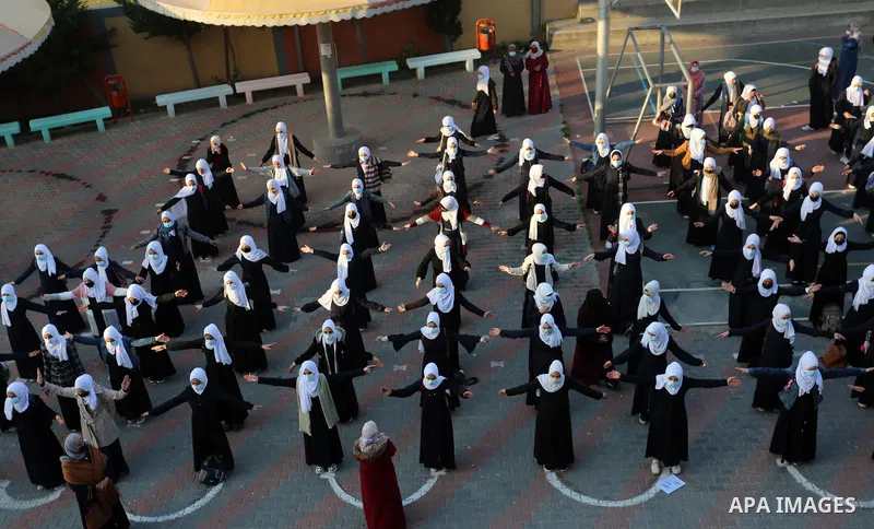 Palestinian students wearing protective face masks, return back to their school, in the morning of the first day of the second semester study, amid the coronavirus disease (COVID-19) outbreak, in Dair Al Balah in the cen...