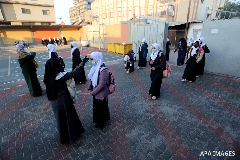 Palestinian students wearing protective face masks, return back to their school, in the morning of the first day of the second semester study, amid the coronavirus disease (COVID-19) outbreak, in Dair Al Balah in the cen...