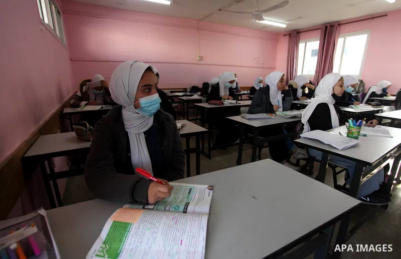 Palestinian students wearing protective face masks, sit in a classroom, in the morning of the first day of the second semester study, amid the coronavirus disease (COVID-19) outbreak, at their school, in Gaza city, on Fe...