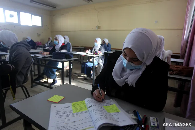 Palestinian students wearing protective face masks, sit in a classroom, in the morning of the first day of the second semester study, amid the coronavirus disease (COVID-19) outbreak, at their school, in Gaza city, on Fe...
