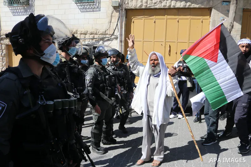 Israeli forces block Palestinian protesters during a demonstration in memory of the 1994 Ibrahimi Mosque massacre, in which a Jewish extremist killed dozens of Palestinian worshippers, in the occupied West Bank city of H...