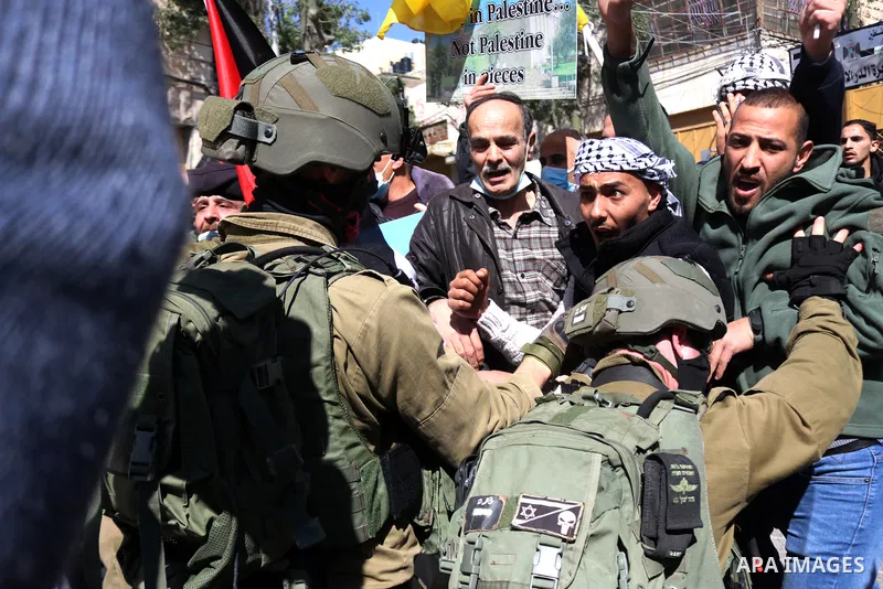 Israeli forces block Palestinian protesters during a demonstration in memory of the 1994 Ibrahimi Mosque massacre, in which a Jewish extremist killed dozens of Palestinian worshippers, in the occupied West Bank city of H...