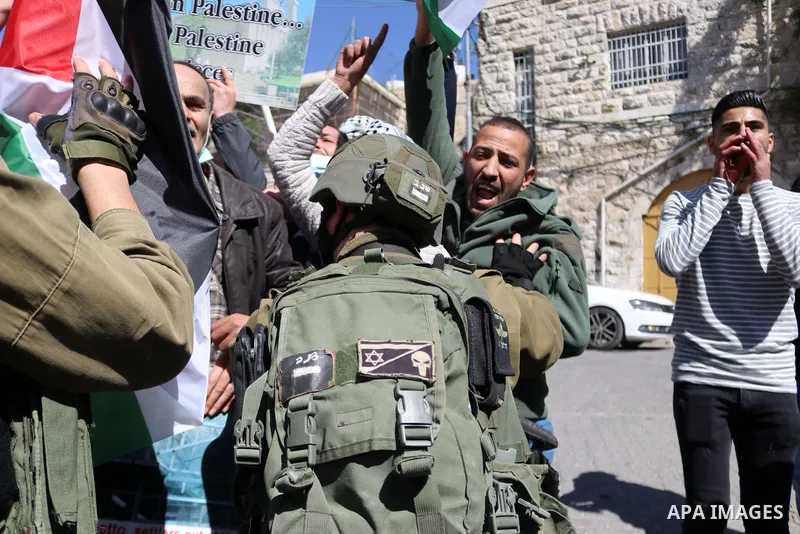Israeli forces block Palestinian protesters during a demonstration in memory of the 1994 Ibrahimi Mosque massacre, in which a Jewish extremist killed dozens of Palestinian worshippers, in the occupied West Bank city of H...